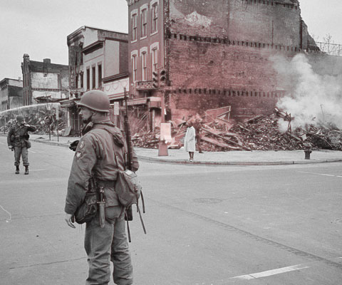 Soldier stands guard in front of building destroyed by riots in Washington, D.C. following the assassination of MLK. (Image: public domain)