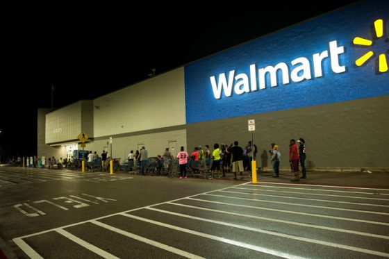 People begin lining up at a closed Wal-Mart store in Beaumont, TX at around 2:30 Thursday morning after hearing the water supply for the city had failed.